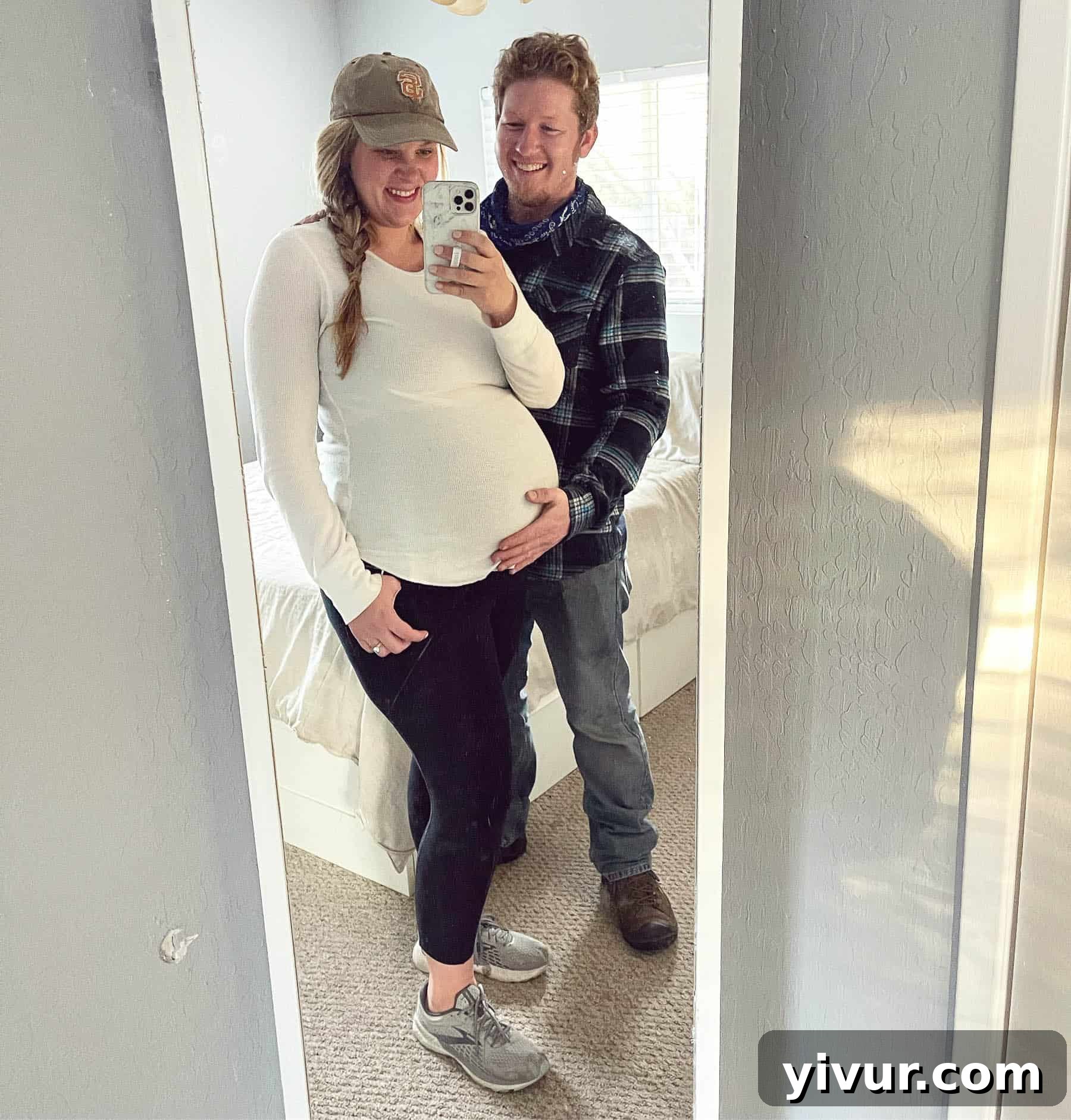 Pregnant woman smiling, holding her baby bump, showing 38 weeks of pregnancy