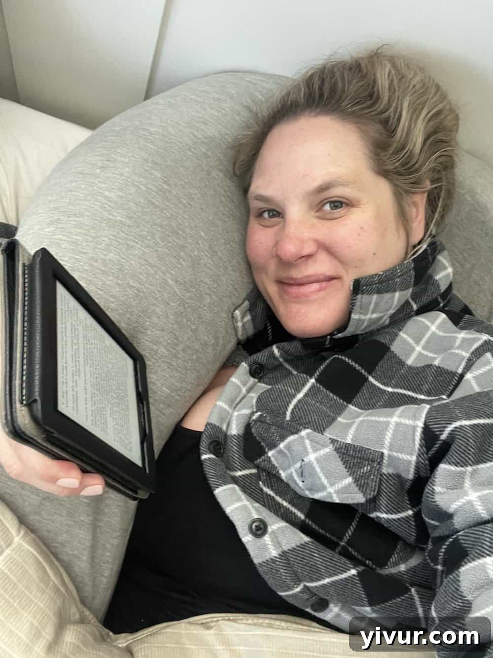Pregnant woman relaxing in bed with a book, anticipating baby's arrival, enjoying a moment of peace