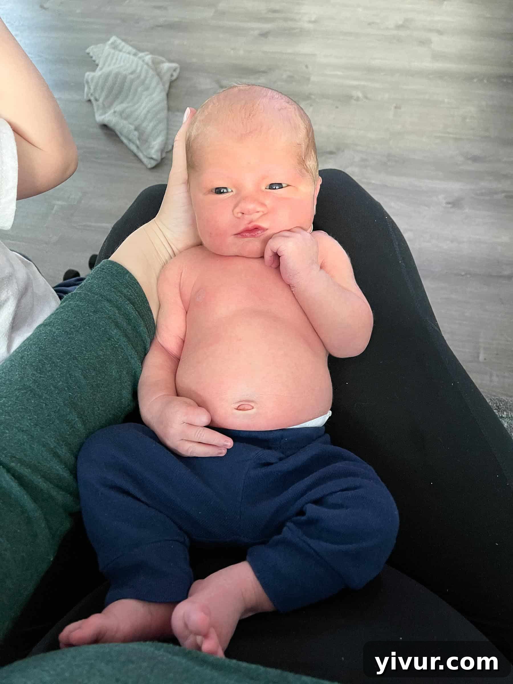 A sweet image of one of Luke's older brothers gently looking down at the newborn, showcasing sibling love and the innocence of childhood.