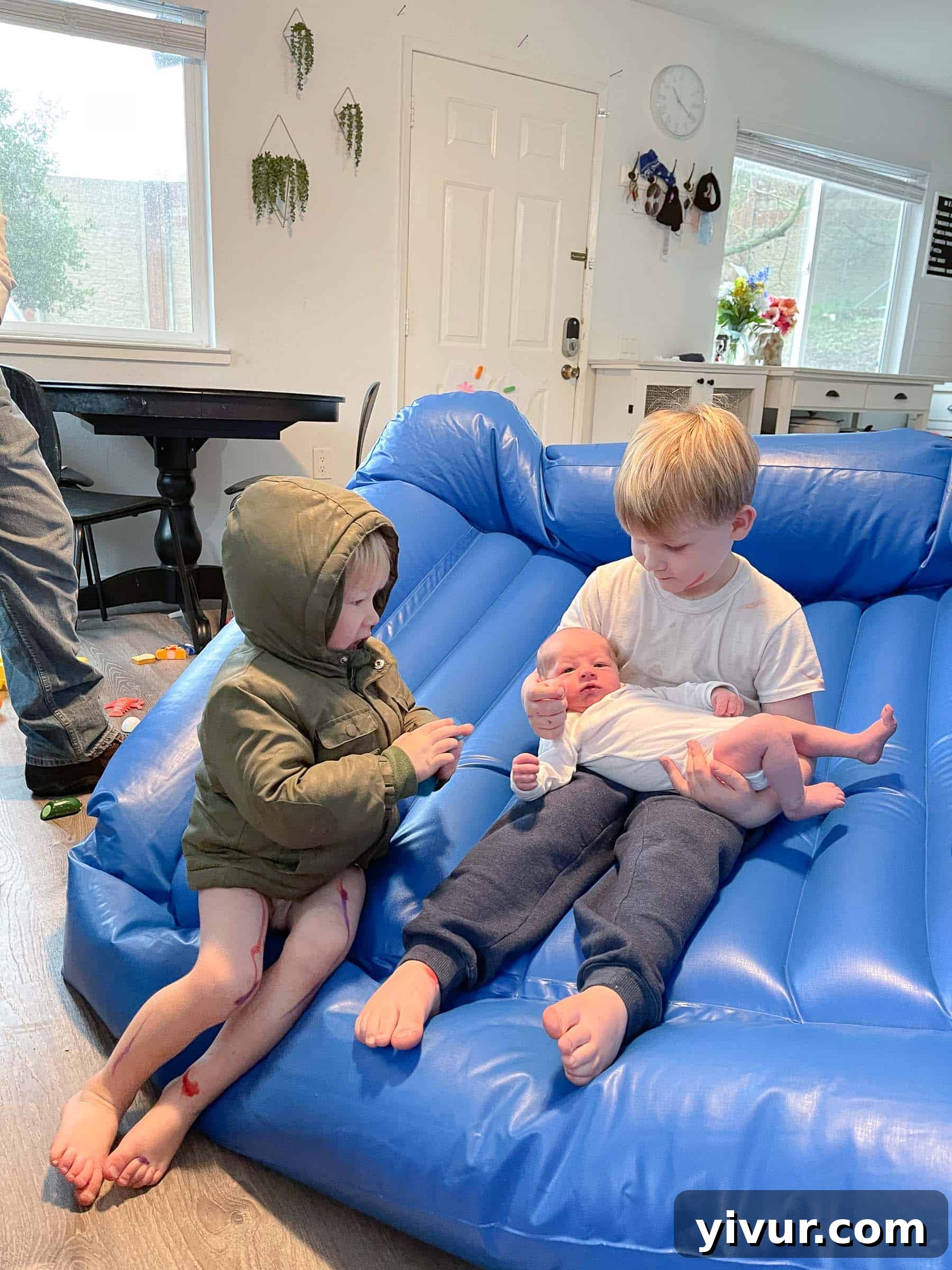 A beautiful family portrait or candid shot featuring all three boys together, perhaps the older ones holding or looking at Luke, highlighting the new family dynamic.
