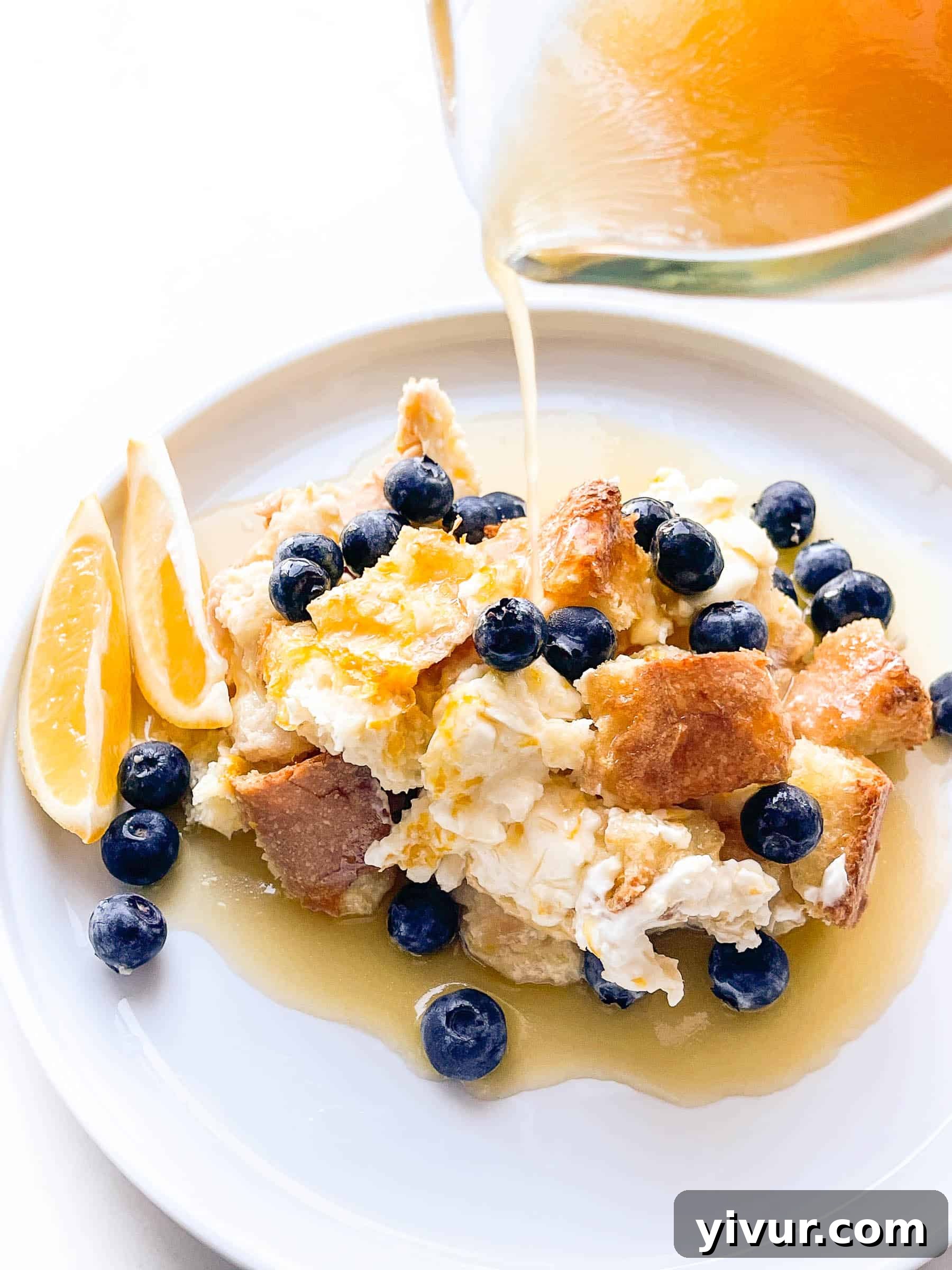 Delicious overnight French toast casserole with cream cheese and fresh blueberries, garnished with lemon slices