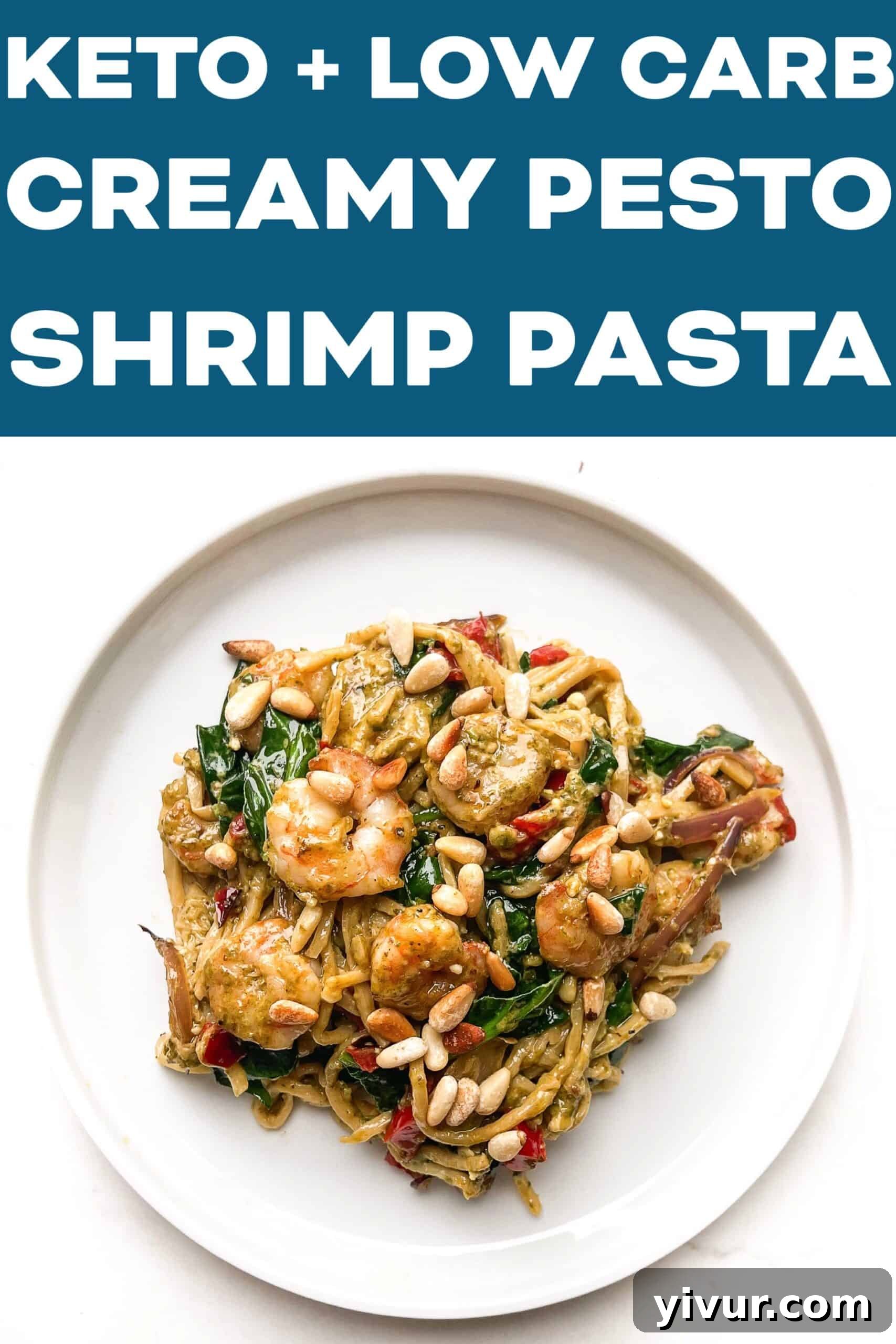 A top-down view of a hand reaching for a forkful of creamy pesto shrimp pasta from a white plate, highlighting the delicious texture and presentation.