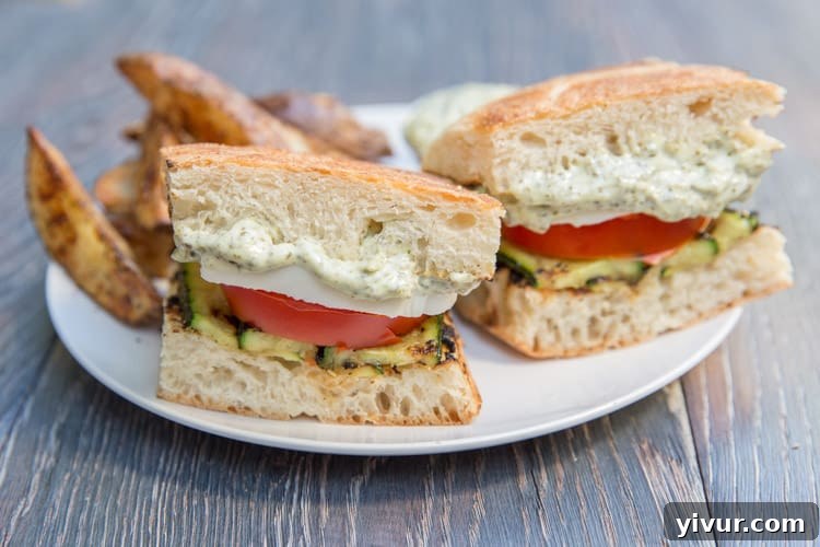 Closeup of a freshly prepared Grilled Zucchini Caprese Sandwich with vibrant layers of tomato and mozzarella.