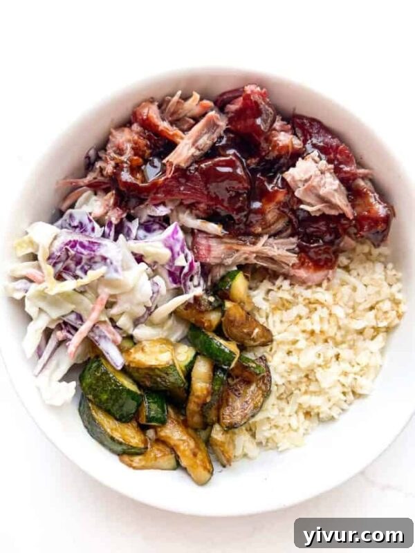 Sizzling Keto Summer: 15 Must-Try Grilling Recipes 3 A beautifully presented Keto BBQ Pulled Pork Bowl, featuring tender pulled pork, cauliflower rice, fresh avocado, and vibrant coleslaw.