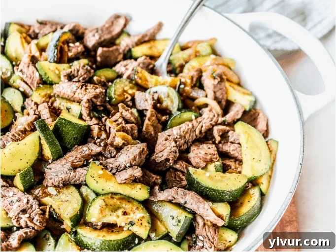 A mouth-watering steak and zucchini stir fry served in a rustic bowl, featuring perfectly seared steak, crisp green zucchini, and colorful bell peppers.