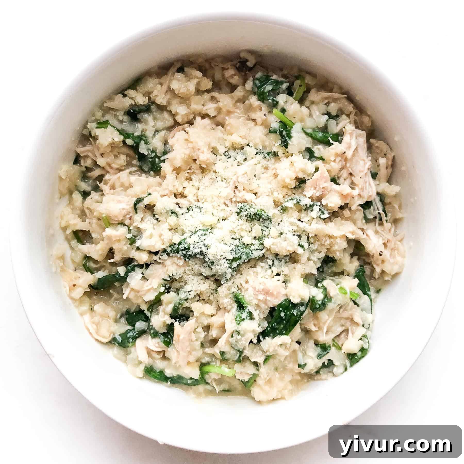 Instant Pot Keto creamy mushroom chicken cauliflower rice casserole with spinach and parmesan in a white bowl.
