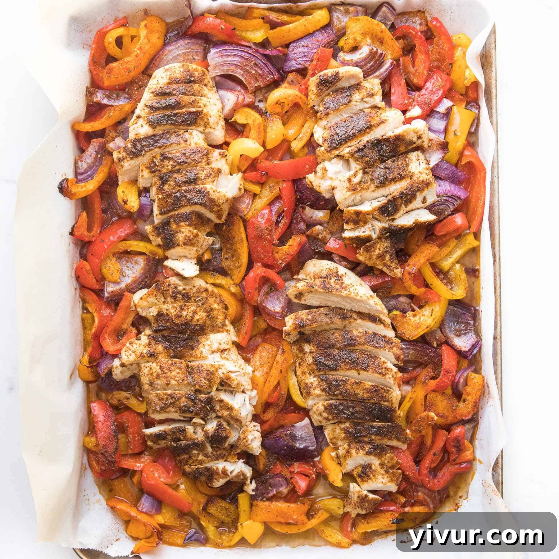 Vibrant Keto sheet pan chicken fajitas, seasoned and roasted with bell peppers and onions.