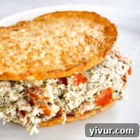 keto pesto chicken salad on cauliflower thins on a white plate with a white background