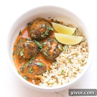 Keto Thai curry meatballs in a creamy sauce, garnished with fresh herbs.