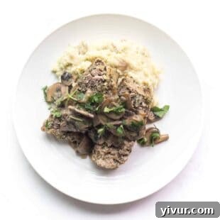 Slice of Paleo and Whole30 meatloaf generously topped with mushroom gravy.