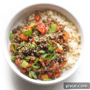Vibrant Whole30 and Keto Asian Beef Bowls stir-fry with bell peppers and green onions.