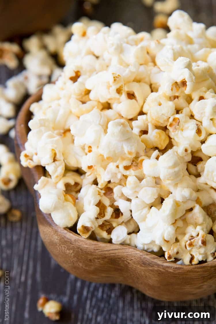Close-up shot of this kettle corn recipe in a clear bowl, highlighting the glossy, caramelized sugar coating and crunchy texture.