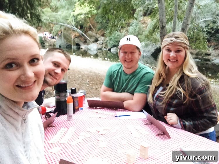 Four friends gathered around a crackling campfire under the night sky, enjoying a cozy camping evening at Big Sur, sharing stories and laughter.