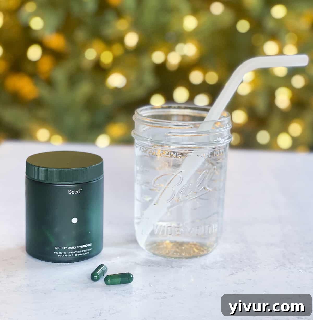 Bounce Back Healthy: Your Post-Indulgence Reset 3 Seed symbiotic and a glass of water with a christmas tree in the background