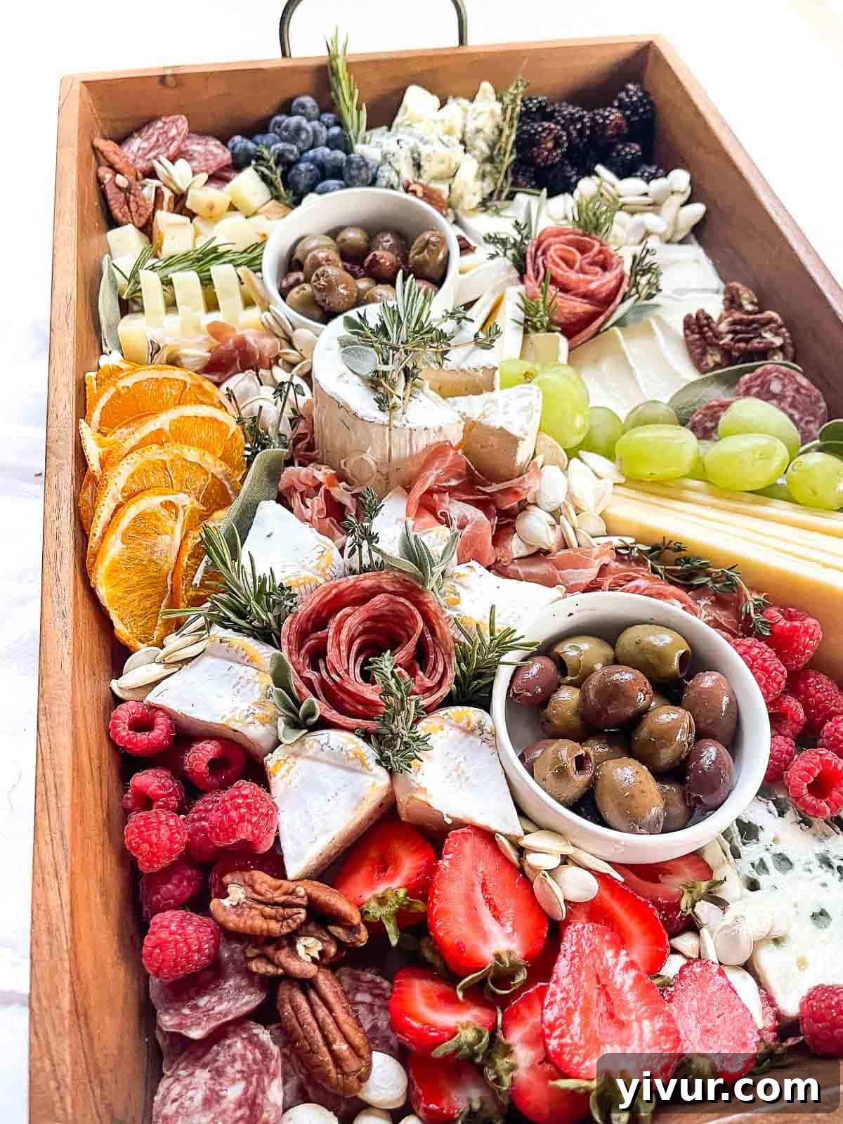 close up shot of a styled Christmas charcuterie board featuring intricate details of cheeses, meats, fruit, and nuts