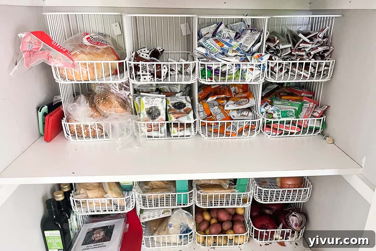 Stackable white wire baskets filled with an assortment of snacks, beautifully arranged in an organized pantry