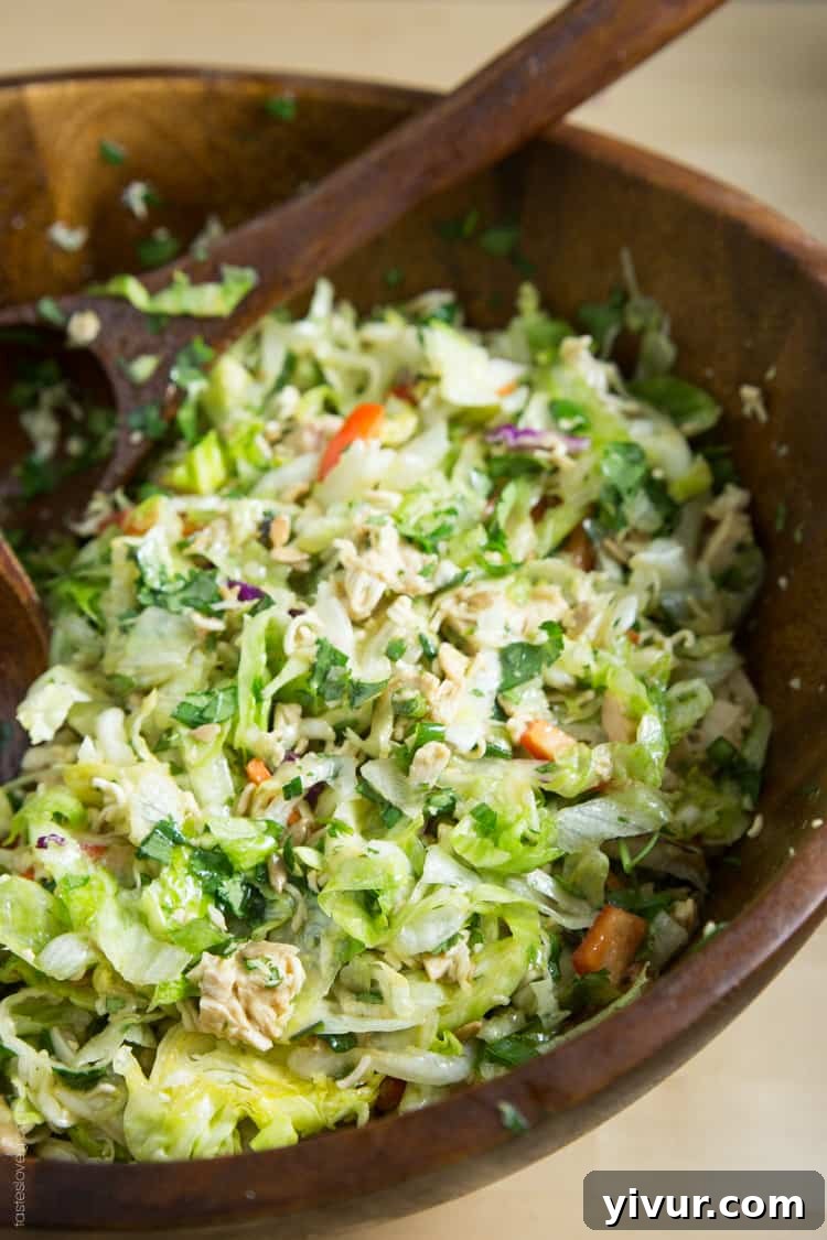 Close-up of the vibrant, fresh ingredients of a Ramen Noodle Chinese Chicken Salad before mixing, highlighting the ramen noodles, cabbage, and bell pepper.