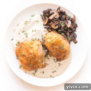 Crispy chicken thighs plated with mashed cauliflower, sautéed mushrooms, and a generous drizzle of creamy mustard sauce.