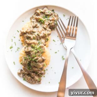 Make Dad's Day Delicious: Keto Recipes and Gift Ideas for Fathers Day 2022 18 Keto biscuits topped with creamy sausage and mushroom gravy in a serving dish.