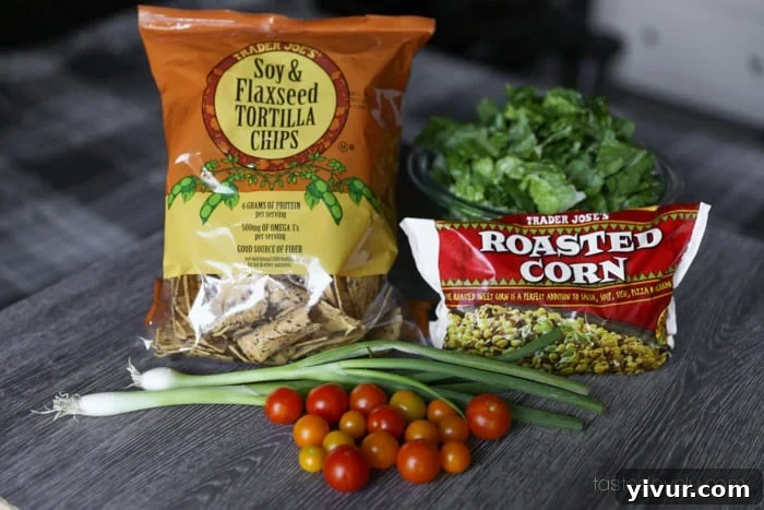 Fresh ingredients laid out on a wooden cutting board for a chopped salad