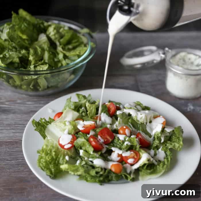 Chopped romaine lettuce, grape tomatoes, and scallions tossed with ranch dressing in a bowl