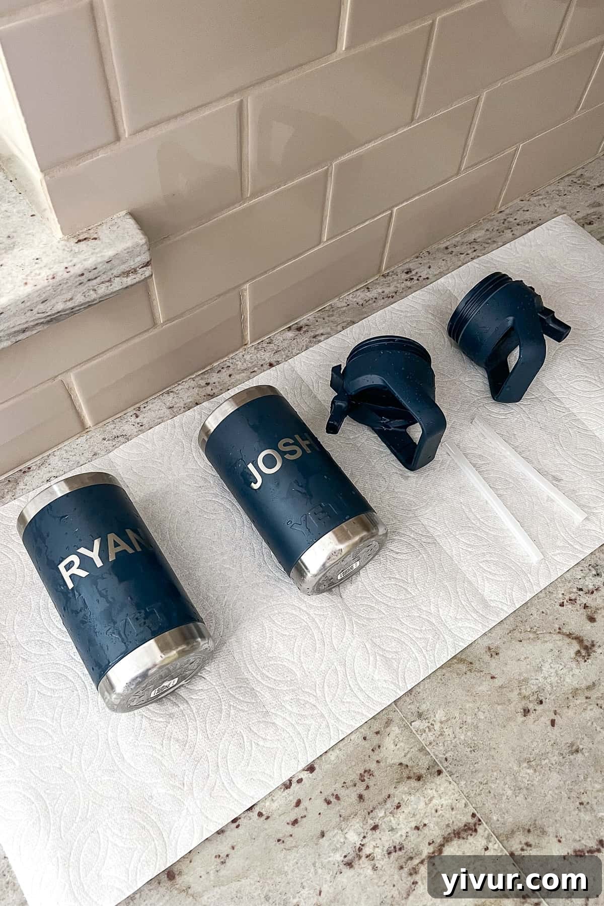 Stainless steel water bottles air-drying upside down on a drying rack on the counter, allowing for proper ventilation and moisture evaporation.