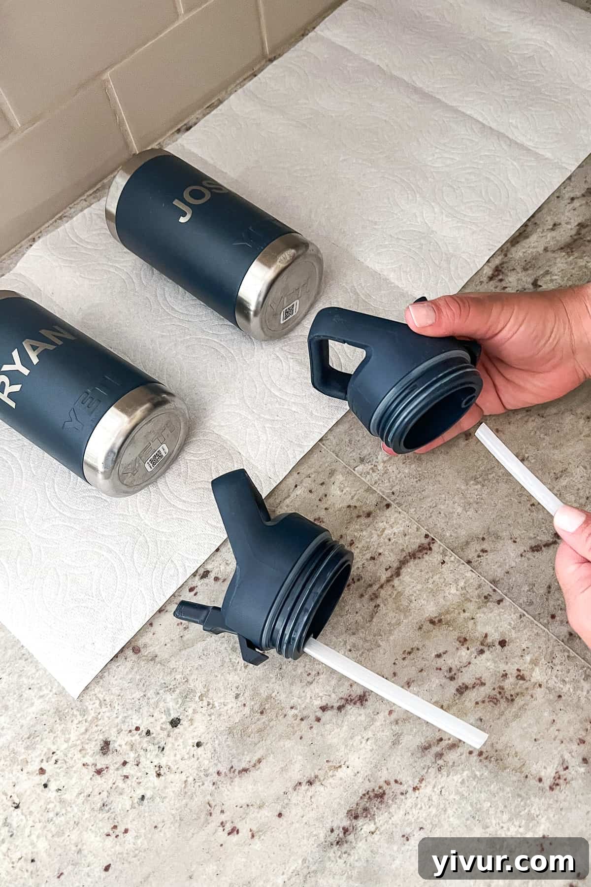 Reassembling clean Yeti water bottles after they have been thoroughly dried, preparing them for reuse.