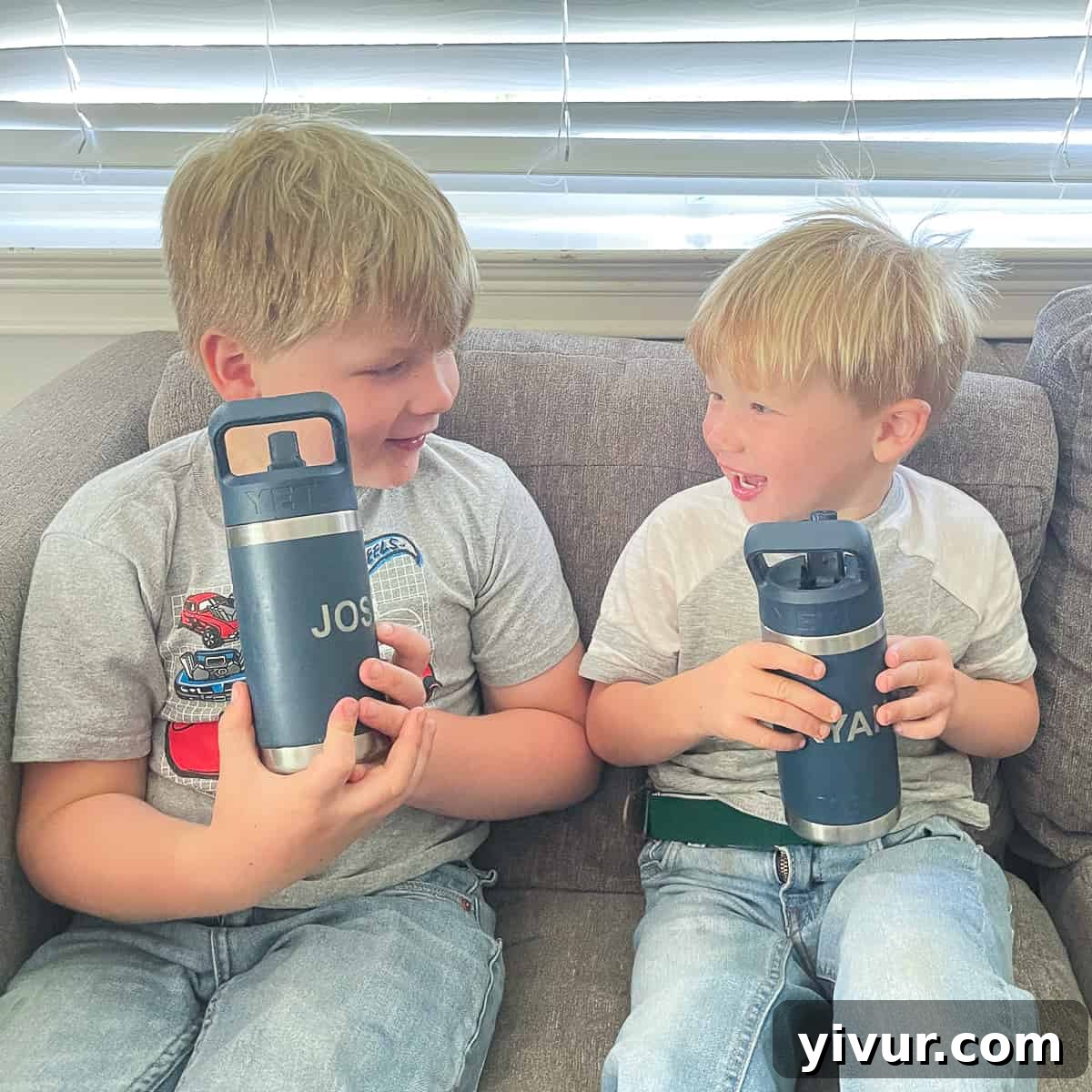 Two young boys happily drinking from their reusable water bottles, highlighting the need for clean and safe hydration for children.
