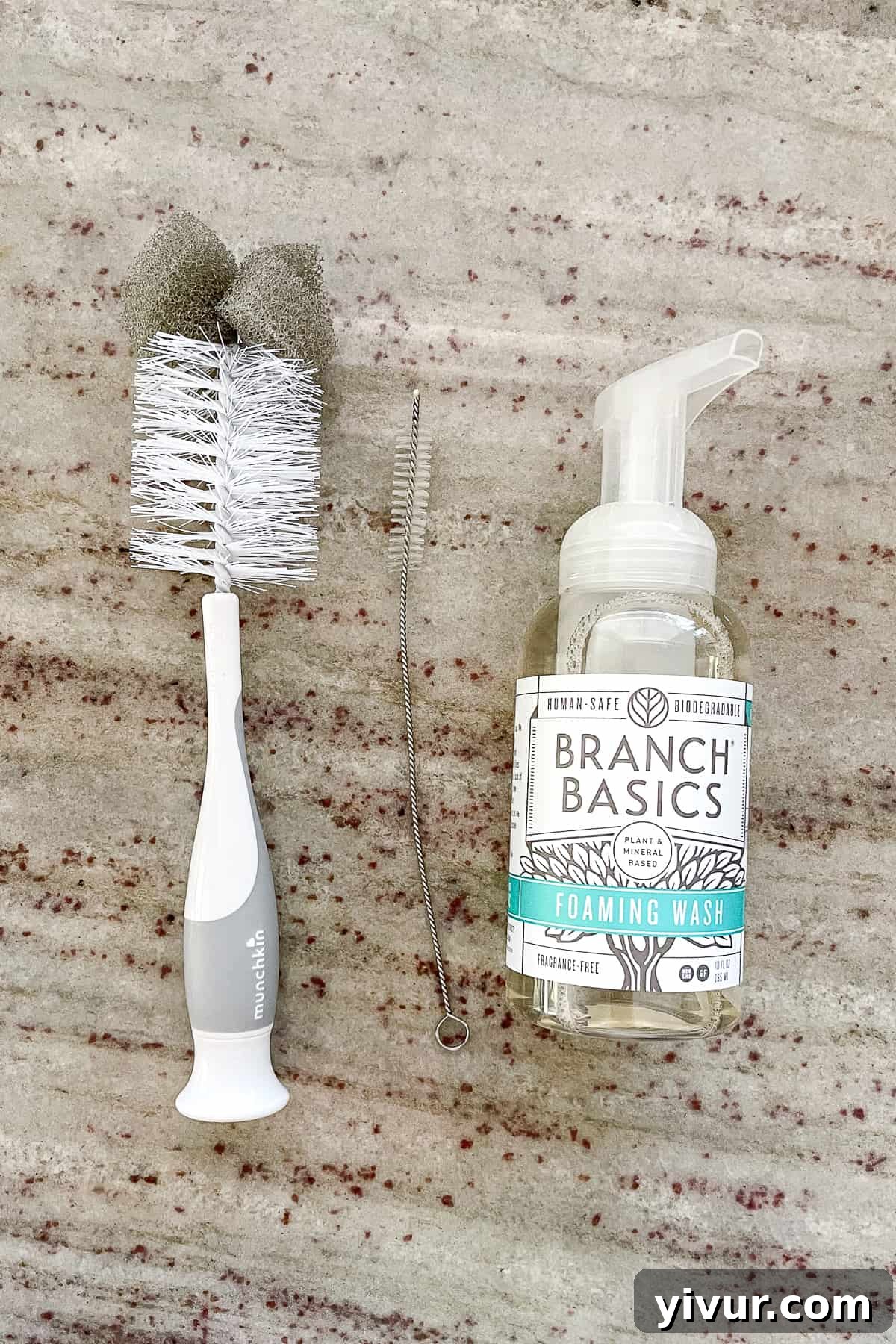 Essential water bottle cleaning supplies, including a bottle brush, straw cleaner, and Branch Basics foaming wash.