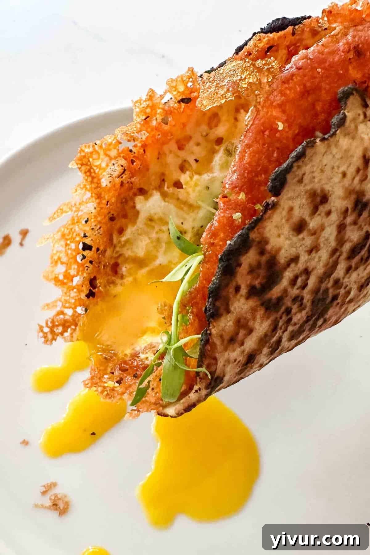 A crispy fried egg taco with a perfectly runny egg yolk dripping onto a plate, highlighting its delicious appeal.