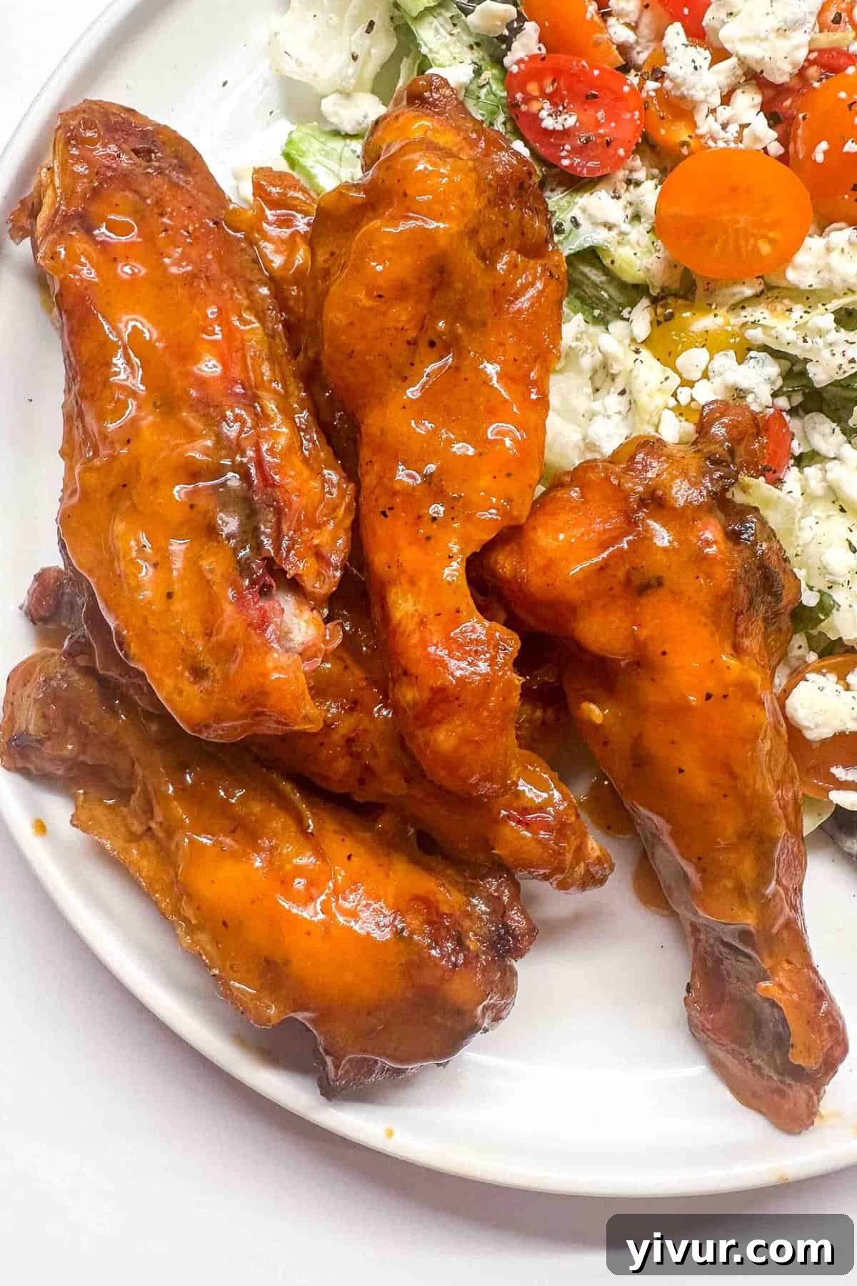 a close up of smoked buffalo wings on a white plate