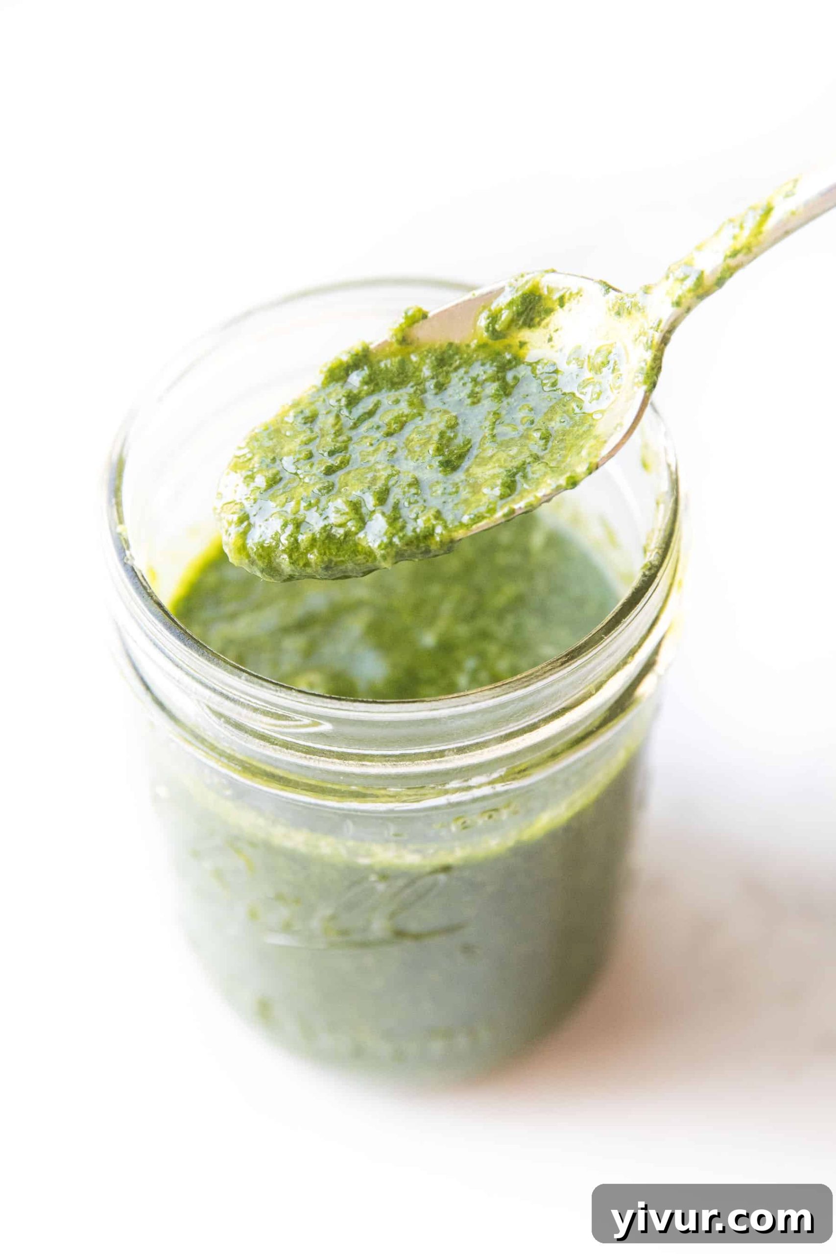 Wholesome Whole30 Chimichurri Sauce Keto and Paleo Friendly 2 Spoon pouring chimichurri sauce into a mason jar, showcasing its vibrant green color