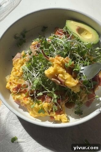 Ham, egg, and cheese scramble with avocado, salsa, and microgreens for a low-carb breakfast