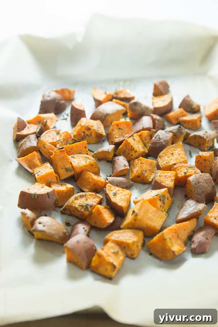 Close-up of perfectly roasted sweet potatoes with fresh rosemary, a simple and healthy side.