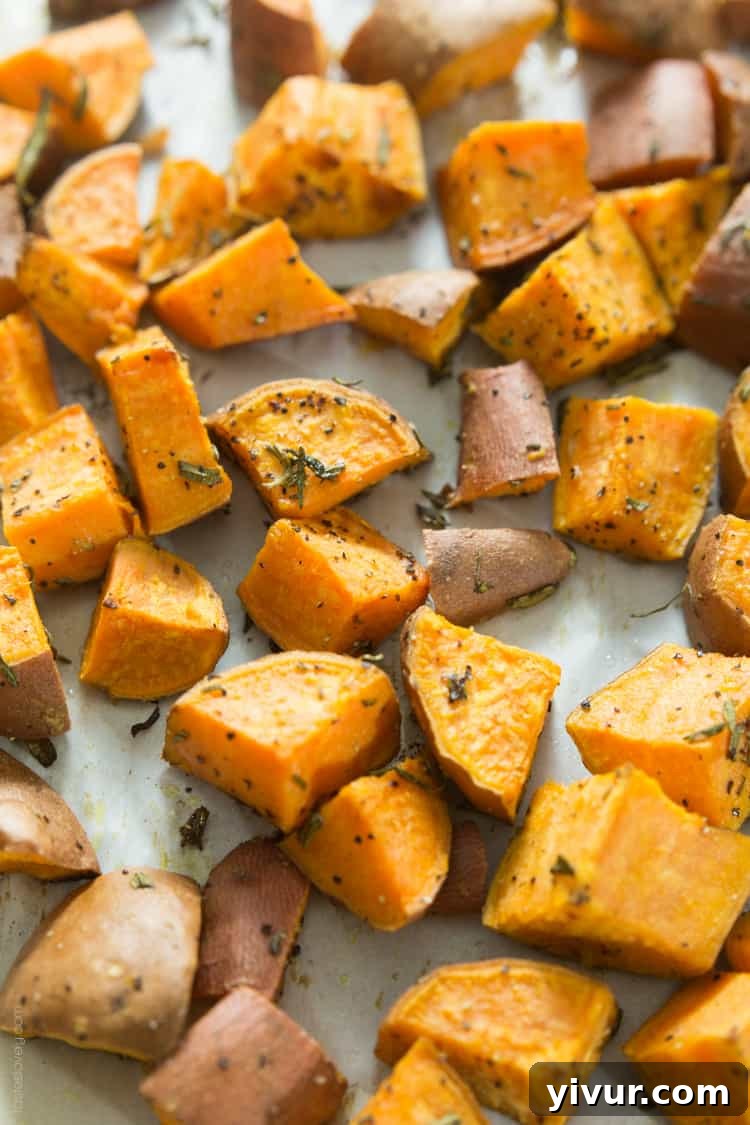 Golden brown Rosemary Roasted Sweet Potatoes on a baking sheet, ready to serve.
