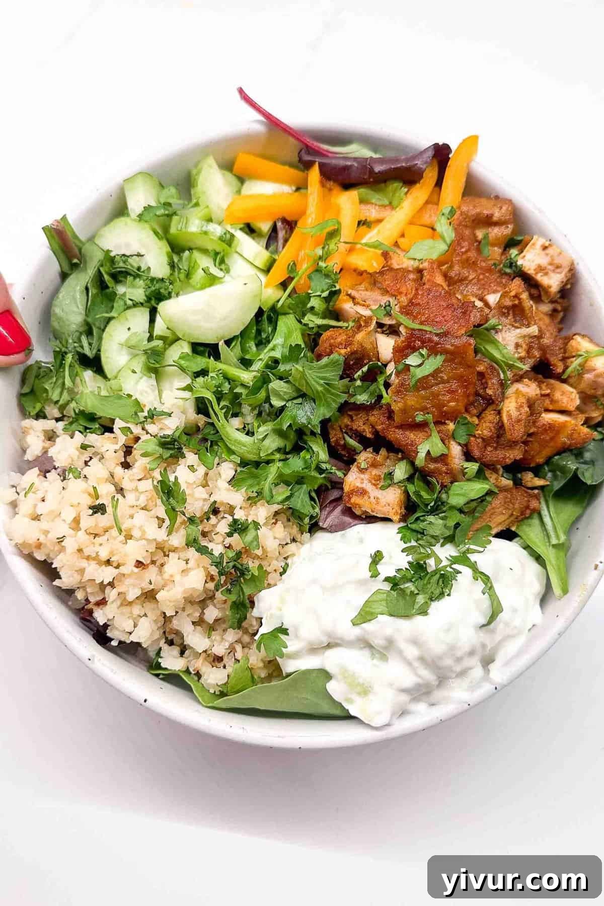 chicken shawarma bowls filled with rice, tzatziki, greens, and fresh veggies