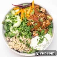 chicken shawarma bowls filled with rice, tzatziki, greens, and fresh veggies