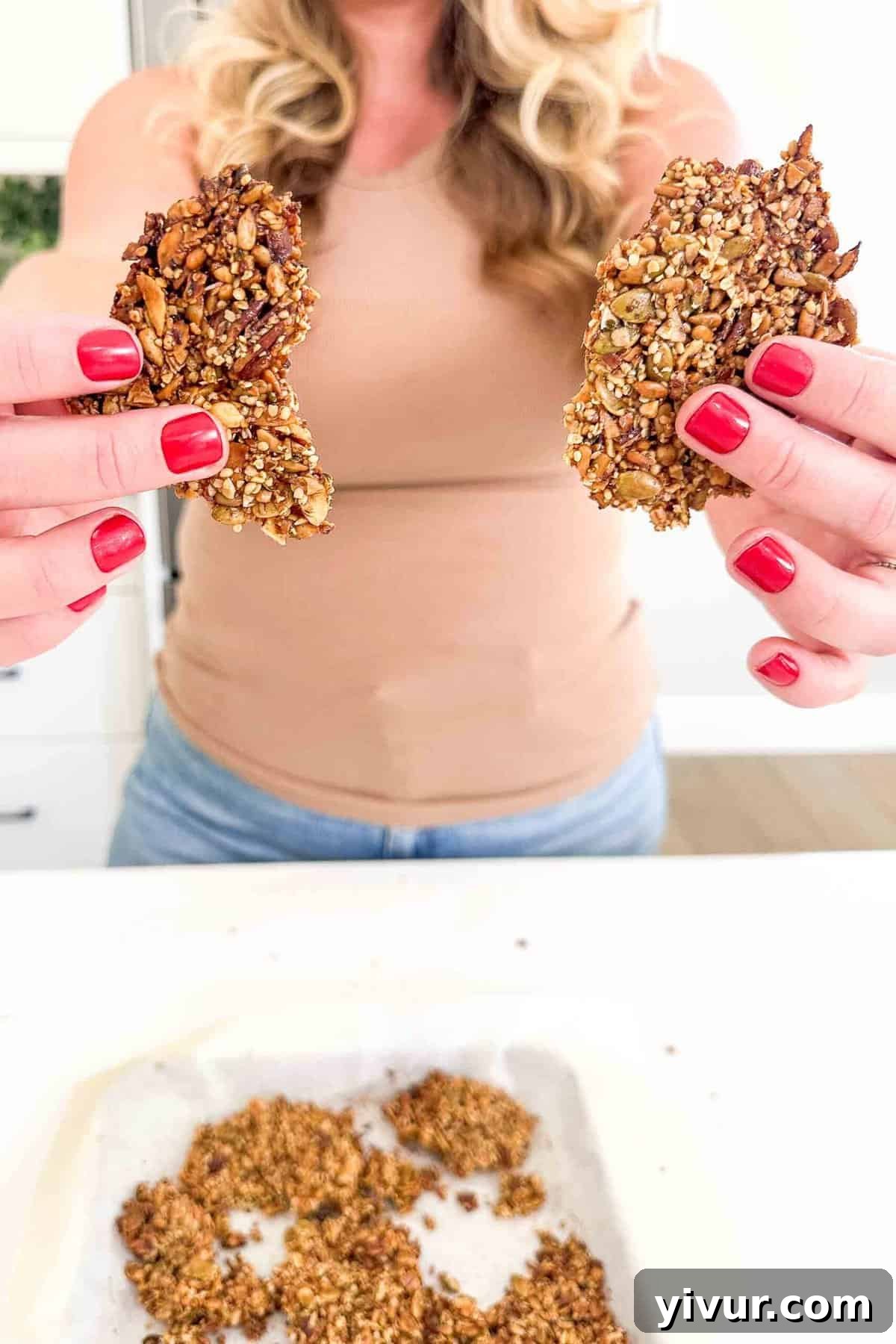 hands holding two pieces of grain free granola 