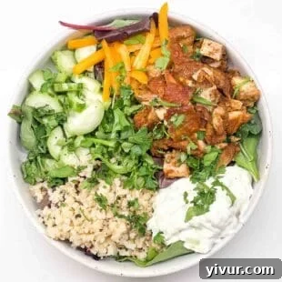 chicken shawarma bowls filled with rice, tzatziki, greens, and fresh veggies