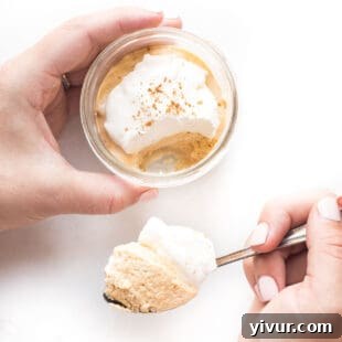 Individual no-bake keto pumpkin cheesecake jars, showing layers of creamy filling and crunchy crust, ready to be enjoyed.