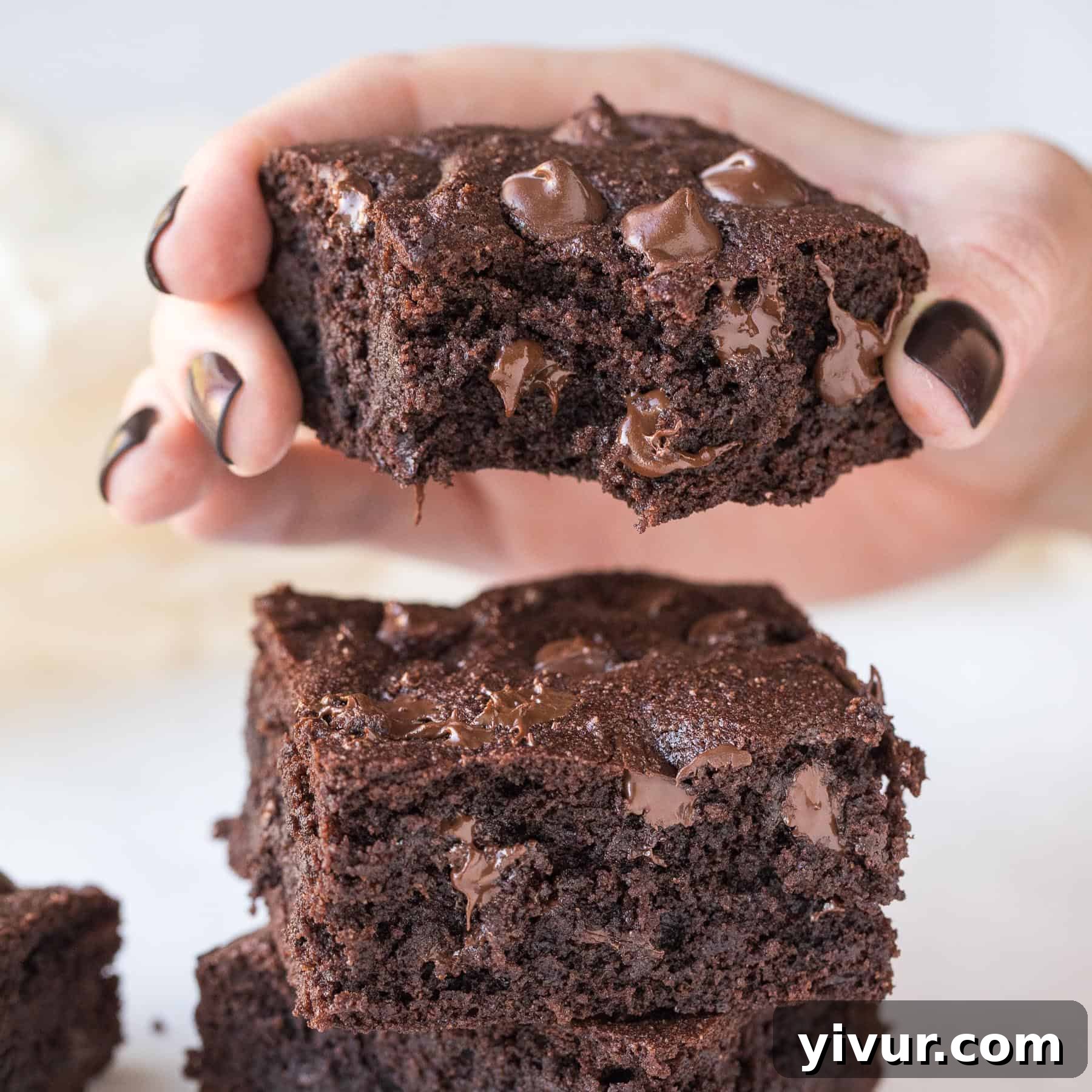 Close-up of a square of rich, fudgy keto brownie, showcasing its moist texture and chocolate chips.