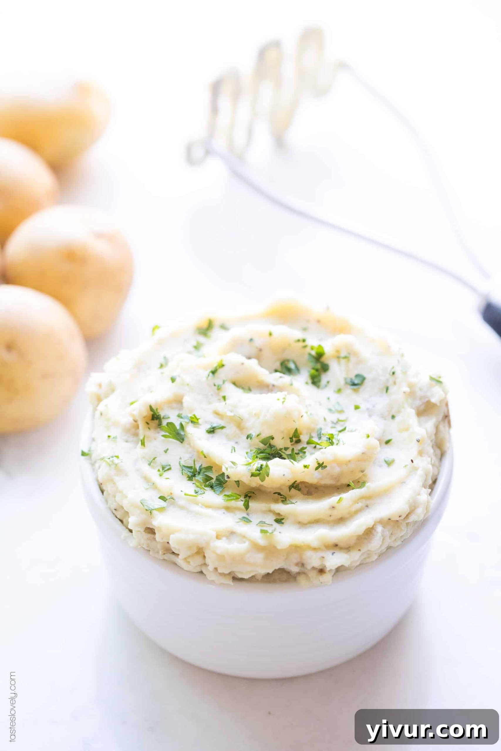 Creamy mashed cauliflower in a small bowl garnished with fresh herbs, ready to be served at Thanksgiving.
