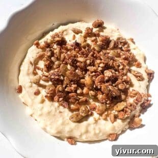 Protein cheesecake filling in a bowl topped with granola