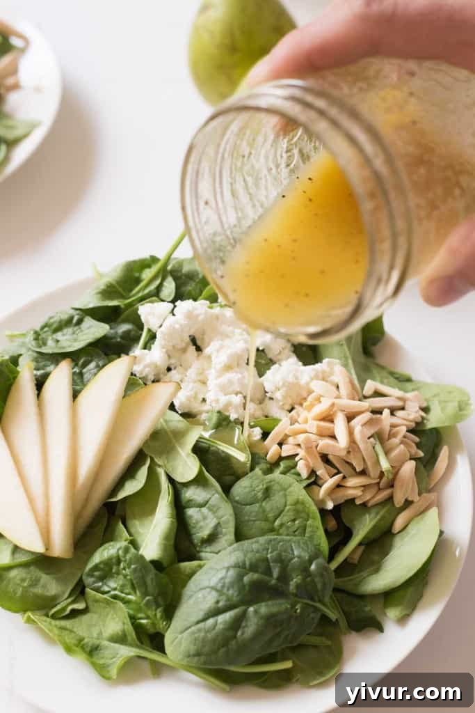 Sweet Pear and Tangy Goat Cheese Spinach Salad 3 A close-up of fresh spinach leaves, creamy goat cheese, and sweet pear slices, ready for a delicious salad. #glutenfree #vegetarian