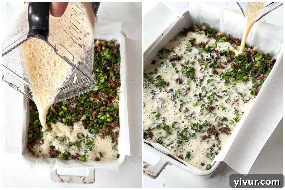 Pouring the blended egg mixture over the layers of potatoes, bison, and green onions for High Protein Bison Breakfast Casserole