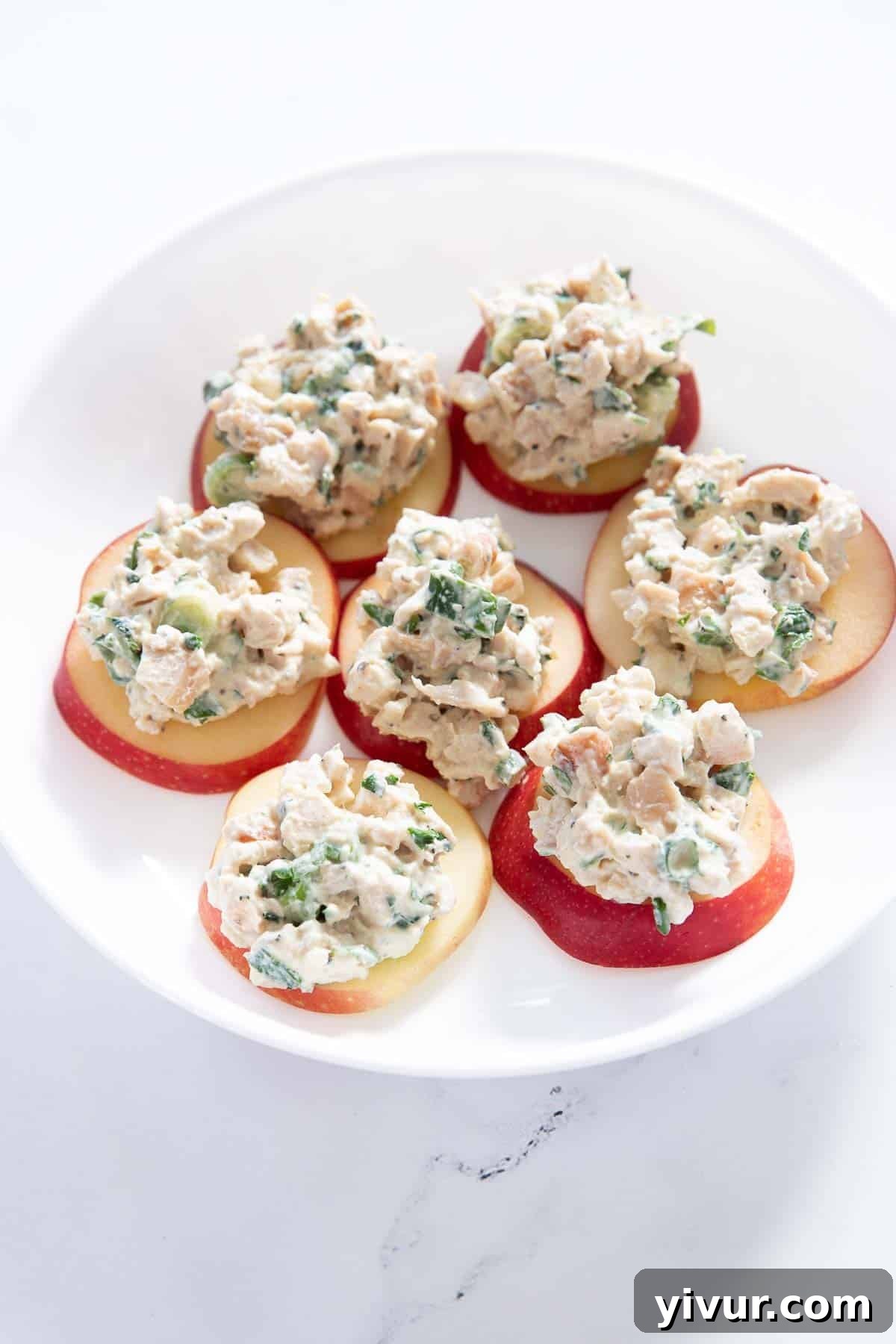 High Protein Creamy Dijon Chicken Salad with Greek Yogurt served on apple on a white plate