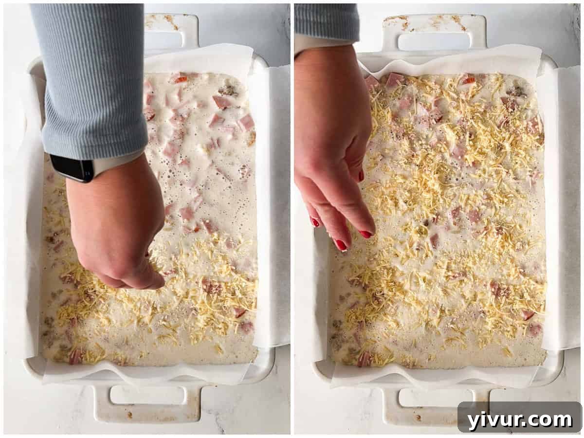 Shredded cheddar cheese sprinkled over the egg mixture in the casserole dish