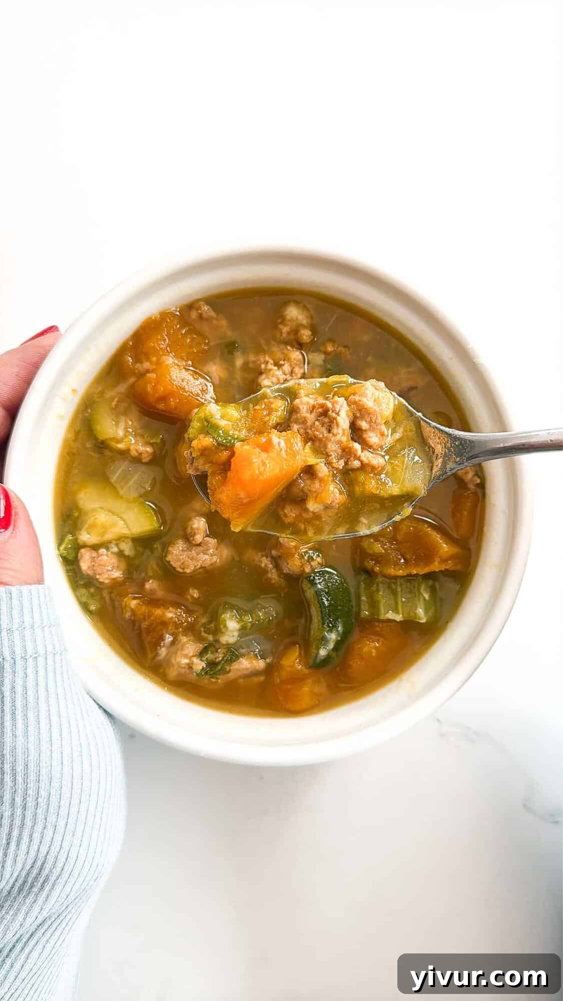 A hearty bowl of high protein turkey and butternut squash soup, garnished with fresh herbs and a sprinkle of parmesan.