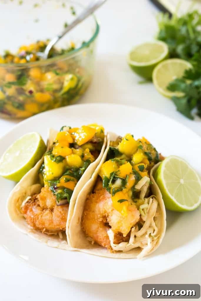 Tropical Coconut Shrimp Tacos with a chili lime coleslaw and mango papaya salsa - seriously the BEST taco I have ever had! Capture the taste of Maui.