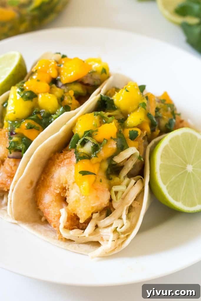 Tropical Coconut Shrimp Tacos with a chili lime coleslaw and mango papaya salsa - seriously the BEST taco I have ever had! A taste of Hawaiian paradise.